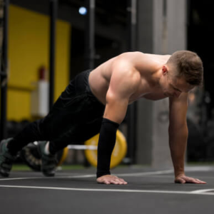 Athlete performing push-ups on the gym floor during a bodyweight workout.